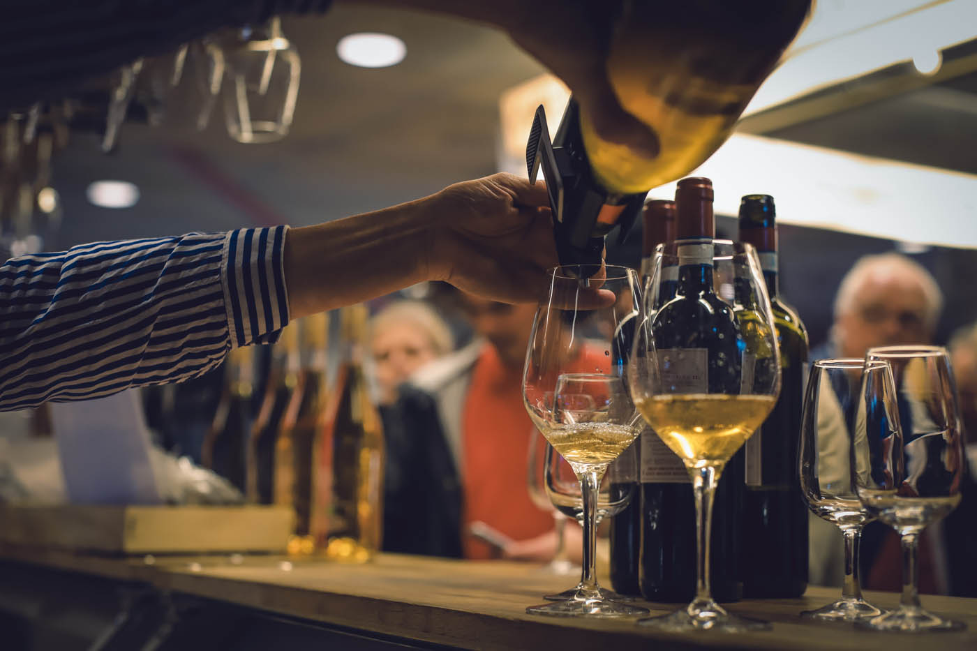 Vitt vin hälls upp i ett glas vid Carls Delis disk